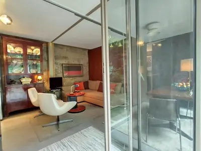 a living room with glass walls and a couch at Garden House in Porto