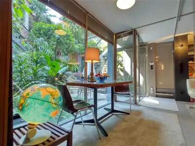 a room with a table and chairs and a glass wall at Garden House in Porto