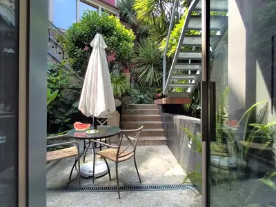 a patio with a table and an umbrella and stairs at Garden House in Porto