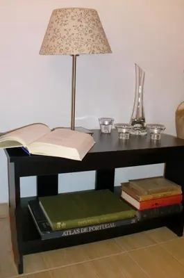 a table with a lamp and books on it at The Yellow House in Vila Nova de Gaia