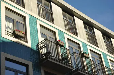 a building with windows and balconies with flowers on them at PicPorto Apartment in Porto