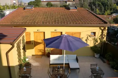 a patio with an umbrella and chairs and a house at The Yellow House 2 in Porto