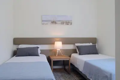 a room with two beds and a lamp on a table at Spot Apartments Ceuta in Porto