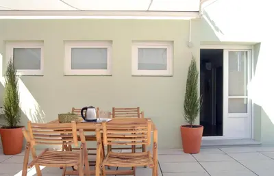 a wooden table and chairs on a patio at Spot Apartments Ceuta in Porto