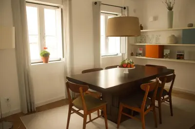 a dining room with a black table and chairs at Arco Apartments in Porto