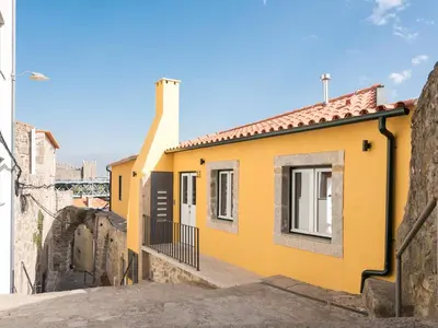a yellow house on a street at Arco Apartments in Porto