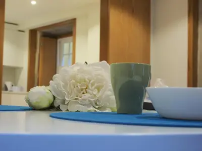a table with a white flower and a cup on it at Belomont6 Apartments in Porto