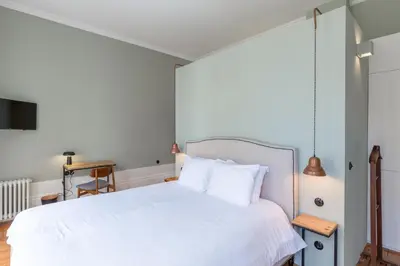 a bedroom with a white bed and a desk at GuestReady - Picaria Living Quarters in Porto