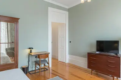 a bedroom with a bed and a desk and a tv at GuestReady - Picaria Living Quarters in Porto