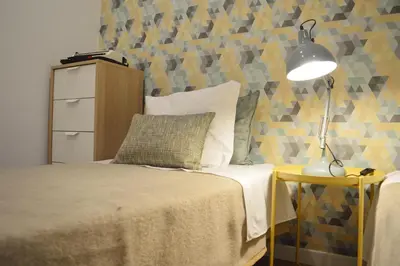a bedroom with a bed and a lamp on a table at T2P Félix House in Vila Nova de Gaia