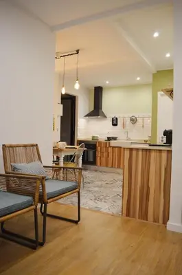 a living room with two chairs and a kitchen at T2P Félix House in Vila Nova de Gaia