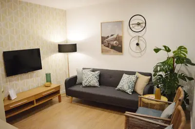 a living room with a couch and a flat screen tv at T2P Félix House in Vila Nova de Gaia