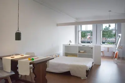 a bedroom with a bed and a table and chairs at Goabio Studio River View in Porto
