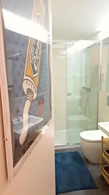 a bathroom with a bottle of beer on the shower door at Flowers Center in Porto