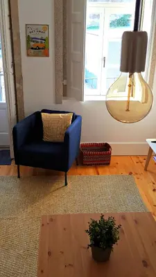 a living room with a blue chair and a lamp at Flowers Center in Porto