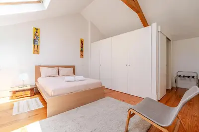 a bedroom with a bed and a chair in it at Apartamento City Center in Porto