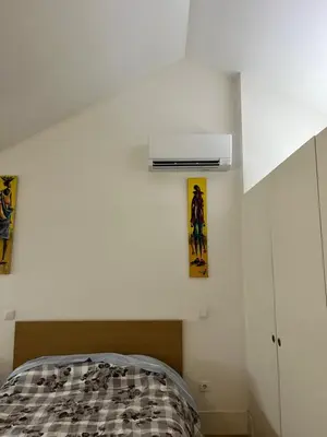 a bedroom with a bed and a white wall at Apartamento City Center in Porto