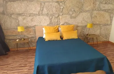 a bedroom with a bed with yellow pillows and two lamps at Sunrise House in Porto