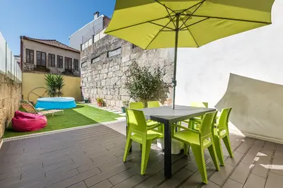 a table and chairs with an umbrella on a patio at Sunrise House in Porto