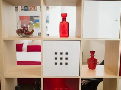 a shelf with red bottles and a bowl on it at OPORTO GUEST - Cedofeita in Porto