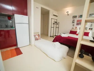 a small room with a refrigerator and a bed at OPORTO GUEST - Cedofeita in Porto