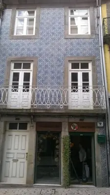 a blue building with white windows and a balcony at Down Bonjardim Apartments in Porto