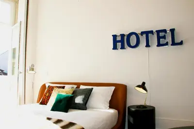 a hotel sign hanging above a bed with pillows at Oporto Chic&Cozy - Batalha in Porto