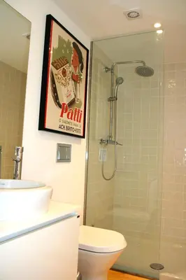 a bathroom with a toilet and a poster on the wall at Oporto Chic&Cozy - Batalha in Porto