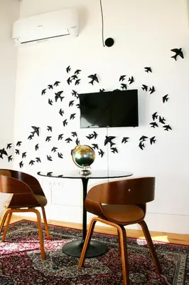 a room with two chairs and a table with birds on the wall at Oporto Chic&Cozy - Batalha in Porto
