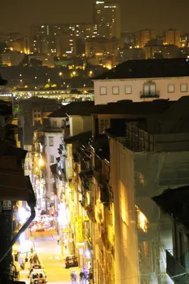 a city street at night with cars and buildings at Andorinha Apartment in Porto