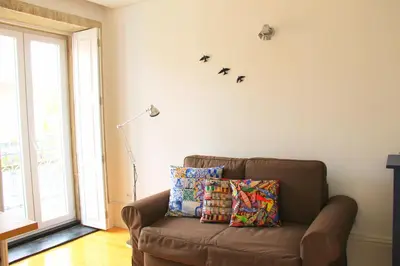 a living room with a brown couch with pillows on it at Andorinha Apartment in Porto
