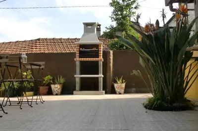 a backyard with a brick patio with a barbecue cooker at The Yellow House 3 in Porto