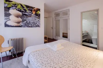 a bedroom with a bed and a painting on the wall at Music House 3 bedroom Apt w garage in Porto