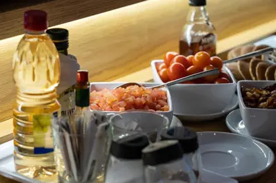 a table topped with bowls of food and bottles of wine at Hotel Spot Family Suites in Porto