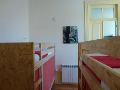 a bedroom with two bunk beds and a window at Canvas Atelier Hostel in Porto