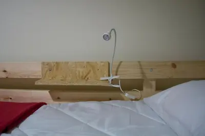 a bedroom with a bed with a light on the wall at Canvas Atelier Hostel in Porto