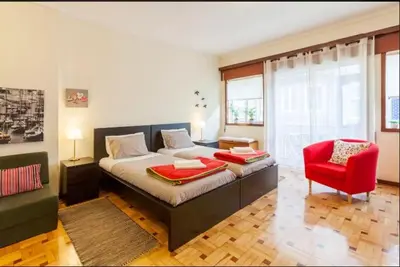 a room with a bed and a table and a kitchen at Cozy loft in downtown in Porto