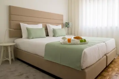 a bed with a tray of food on top of it at Simon Guest Apartments in Porto