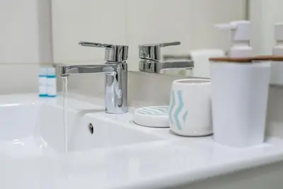 a bathroom sink with a faucet and two cups at Oporto Downtown View Apartment in Porto