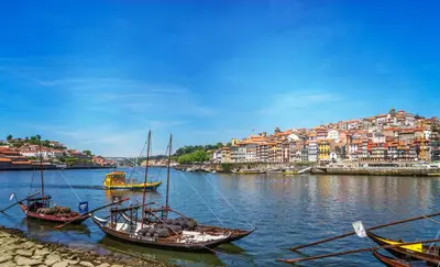 a group of boats in the water with a city at Oporto Downtown View Apartment in Porto
