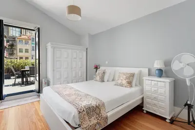a white bedroom with a bed and a window at Mouzinho 244 - Porto Houses & Suites in Porto