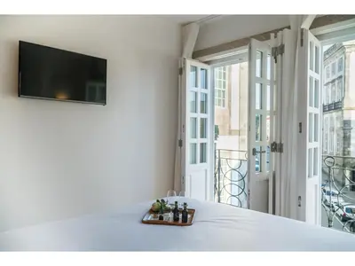 a living room with a flat screen tv on a wall at Ribeiredge Guest House in Porto