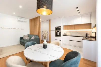 a kitchen and living room with a table and chairs at Casa das Musas in Porto