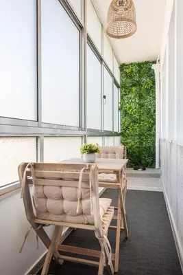 a table and chairs on a porch with windows at Casa das Musas in Porto