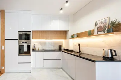 a kitchen with white cabinets and black counter tops at Casa das Musas in Porto