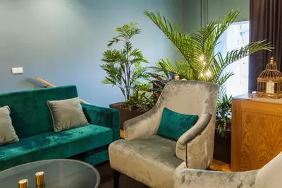 a living room with a couch and a chair and plants at Abbey Apartments City Center Bolhão in Porto
