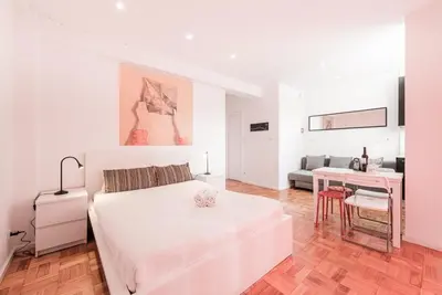 a white bedroom with a bed and a desk at GuestReady - Pratinhas in Porto