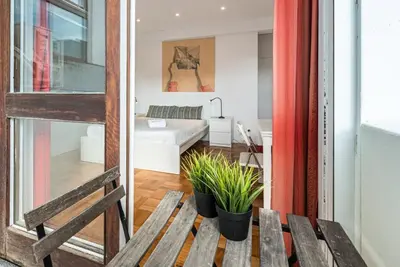 a view of a room with a bench and a bedroom at GuestReady - Pratinhas in Porto