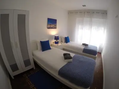 a bedroom with two beds with blue pillows at AP da Baixa in Porto