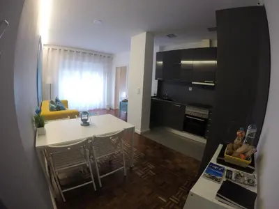 a kitchen and living room with a table and a dining room at AP da Baixa in Porto